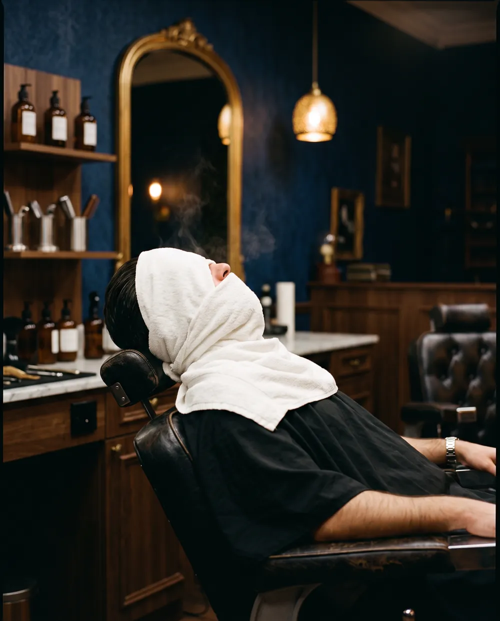 A hot towel wrapped over a reclined client's whole face, only the nose clear, steam rising